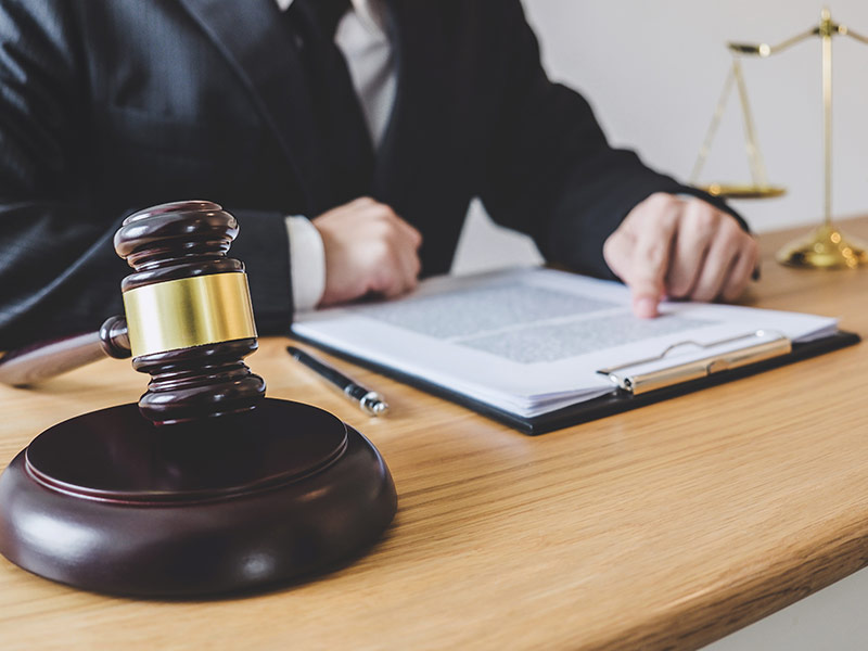 lawyer with gavel at desk filling out paperwork 2